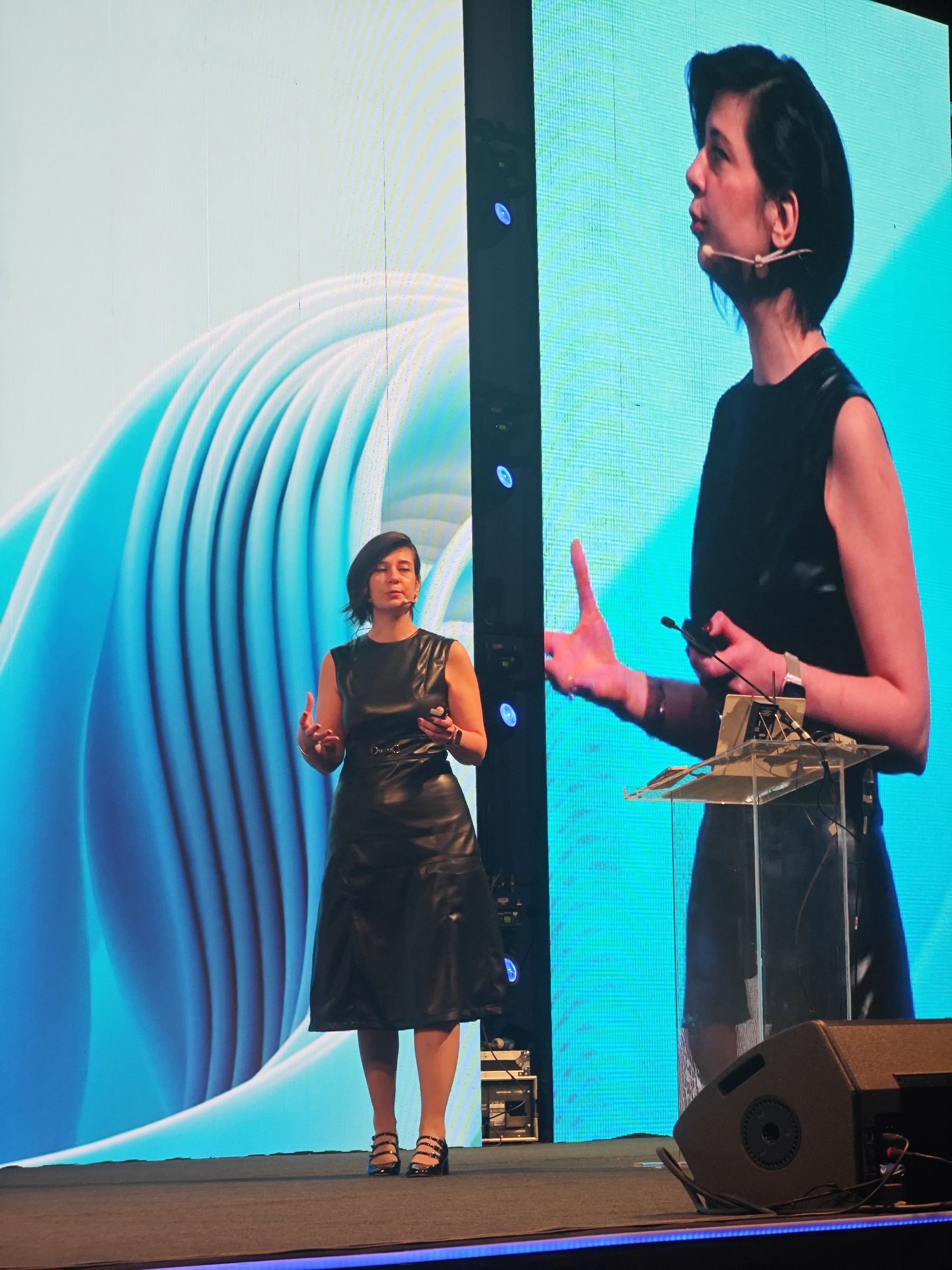 Oya Geron on stage with her image on the LED screen